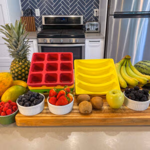 Image of Smootheeze freezer trays surround by fresh fruits and veggies for freezing.