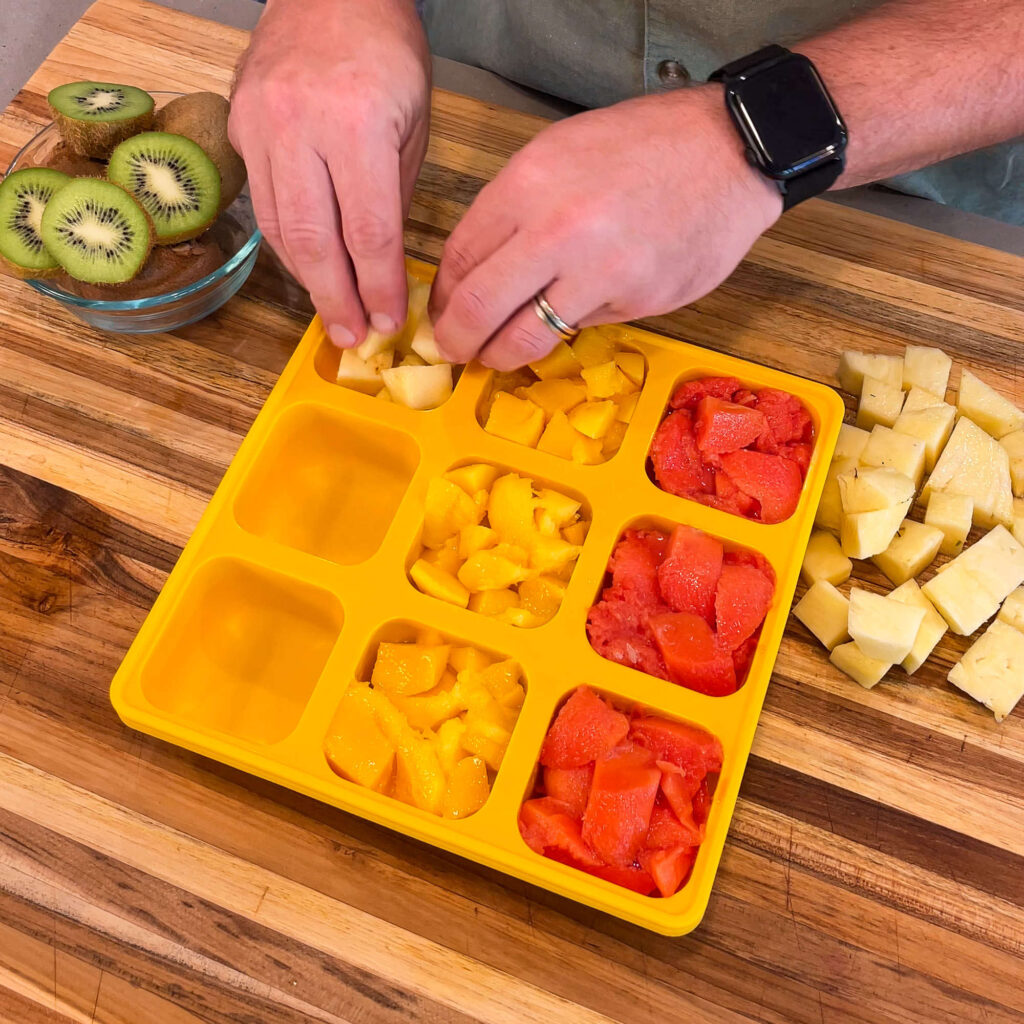 Tropical ingredients being added to a Smootheeze silicone freezer tray