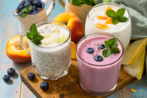 3 colorful smoothies in glasses garnished with fresh ingredients
