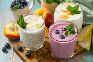 3 colorful smoothies in glasses garnished with fresh ingredients