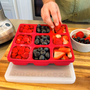 Smootheeze freezer tray being filled with raspberries, blueberries, and strawberries