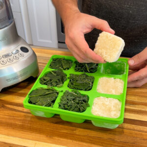 Image of a smootheeze freezer tray with frozen cubes of spinach and cauliflower in it.