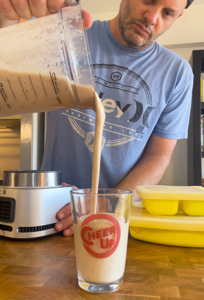 Blended smoothie being poured into a glass