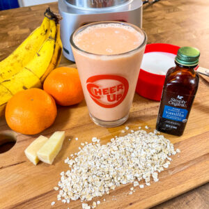 Smoothie in a glass made from oranges, carrots, oats, and ginger