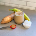 Smoothie in a glass made with sweet potatoes, banana, coconut milk, almond butter.