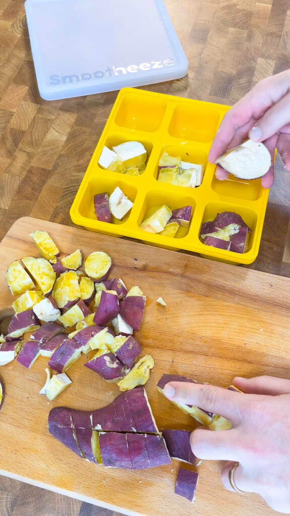 Adding cooked sweet potatoes to a Smootheeze freezer tray to freeze them for smoothies