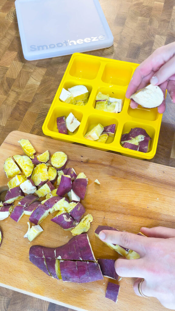 Adding cooked sweet potatoes to a Smootheeze freezer tray to freeze them for smoothies
