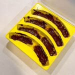 Chocolate covered banana snickers bites in a Smootheeze silicone banana tray