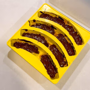 Chocolate covered banana snickers bites in a Smootheeze silicone banana tray